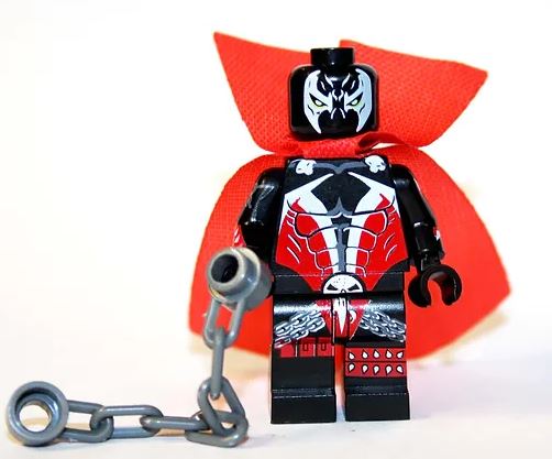 Custom LEGO Spawn minifigure showcasing his signature black and red costume, flowing cape, and distinct facial markings, capturing the essence of the antihero from Image Comics with detailed weapon accessories.